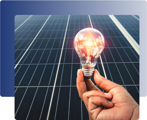 mano sujetando bombilla iluminada con placas solares al fondo